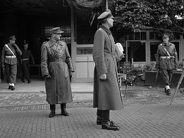 De Duitse delegatie bij Hotel De Wereld. Rechts met platte pet luitenant-generaal Reichelt, links een tolk.