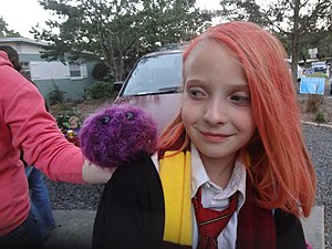 Cosplay de Ginny Weasley avec son Boursouflet sur l'épaule.