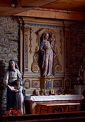 Photographie d'un autel accompagné à gauche d'une statue d'Éducation de la Vierge