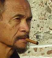 An older man, Goenawan Mohamad, smoking