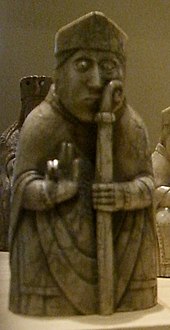 Photograph of an ivory gaming piece depicting a seated bishop