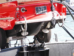 Une Amphicar sur une péniche d'habitation, hélices et tuyau d'échappement.