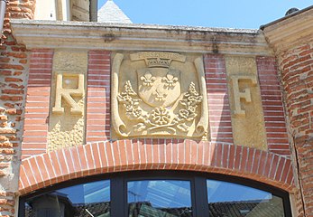 Le blason de la commune sculpté sur la mairie.