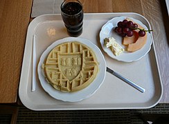 A breakfast consisting of a novelty-stamped waffle, cantaloupe melon slices, grapes, and butter