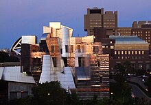 striking geometric metallic building in front of more traditional ones