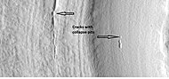 Close-up that shows cracks containing pits on the floor of a crater containing concentric crater fill, as seen by HiRISE under HiWish program