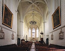 Vue générale de l'intérieur d'un édifice religieux, vu dans l'axe de sa nef.