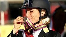 Photo of Morganti smiling while holding a medal