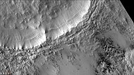 Short dark streaks are dark fans caused by outgassing of carbon dioxide and dark material. Layers are easily visible in the wall of the crater. Note: this is an enlargement of the previous image of McMurdo. Picture taken with CTX camera (on Mars Reconnaissance Orbiter).