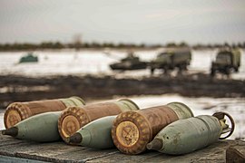 Des obus explosifs à fragmentation de 125 mm accompagnés de leurs charges propulsives respectives.