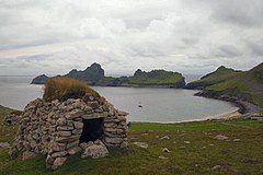 Kamenná chýše, tzv. "cleit", nad zátokou Village Bay