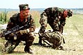 A 10th SFG (A) operator using an M4 carbine left-handed during an exercise with another soldier in July 1995.