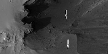 Boulders and their tracks from rolling down a slope, as seen by HiRISE under HiWish program. Arrows show two boulders at the end of their tracks.