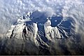 Fotografia de um astronauta destacando a cratera do cume e os declives cobertos de neve do Avatchinski.