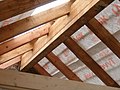 A heavy ridge beam and rafters. A tie or joist visible in foreground