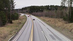 Image of Finnish national road 5 with three cars at Kuortti in Pertunmaa. The picture has been taken from the perspective of the bridge at Kuortti's interchange.