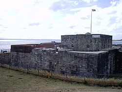 Et lavt, grått slott av sten ved havet