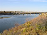 A wide river flows under a bridge.