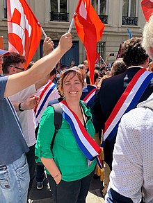 Élise Leboucher portant son écharpe de députée lors d'une manifestation.