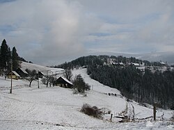 Levo: zaselek Svete Planine, v ozadju: hrib Sveta planina, Planinski dom Partizanski vrh in cerkev Imena Marijinega