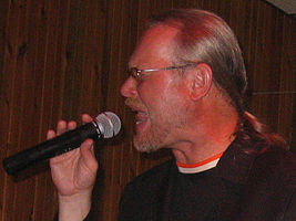 close-up profile of Vašo Patejdl singing into a microphone with eyes closed