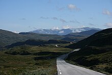 Foto einer schmalen Straße, die durch eine Berglandschaft führt