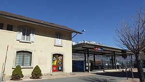 Two-story building with gabled roof and adjoining canopy-covered platform