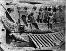 A galley with its oars out equipped with a small tower-like structure and a group of battle-ready Roman legionnaires standing on the upper deck