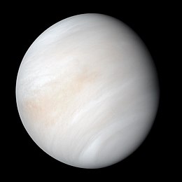 Venus in approximately true colour, a nearly uniform pale cream, although the image has been processed to bring out details.[۱] The planet's disc is about three-quarters illuminated. Almost no variation or detail can be seen in the clouds.