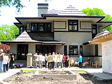 A recent straight on shot of the west elevation taken from the far end of the backyard. The new garage is visible at right. A large group of people in the backyard are taking part in the Wright Plus 2009 Home tour.