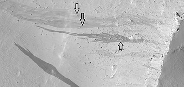 Dark slope streaks, as seen by HiRISE under the HiWish program. Arrows show how boulders affected the shape of the streaks.