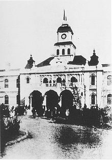 A black and white photo of a hall featuring a clock tower