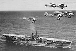 Le HMS Ark Royal en 1939, survolé par des Fairey Swordfish.