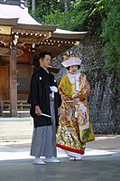 神道形式の結婚式における新郎と新婦。花婿が紋付・袴を、花嫁が色打掛を着用している。結婚式の和装としてのこの組み合わせは明治以後に一般的となった[37]。