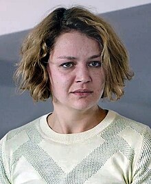 Luise Heyer wearing a light-coloured, patterned top, looking expressionlessly just left of camera