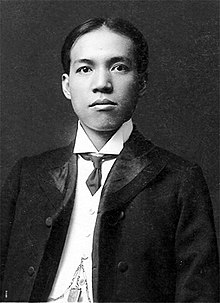 A black and white photograph of Liang Qichao in a suit