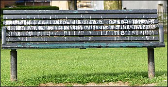 Fientes de corneilles sur un banc public disposé sous un arbre de Shoreditch Park (Londres, Angleterre), le banc servant lui-même de reposoir.