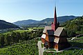 Ringebu stavkirke sett fra luften med Gudbrandsdalen og Ringebu i bakgrunnen.