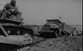 US Navy Seabee bulldozer is used to get a truck loaded with cargo ashore