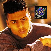 The cover features a black man wearing a grey sweater, sporting a hi-top fade and unibrow. On his left in a black square is the artist's name and album title.