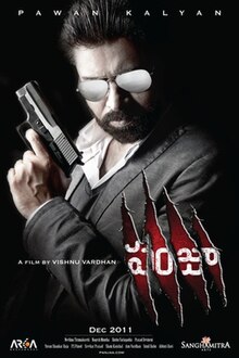 Bearded man in black suit holding a gun